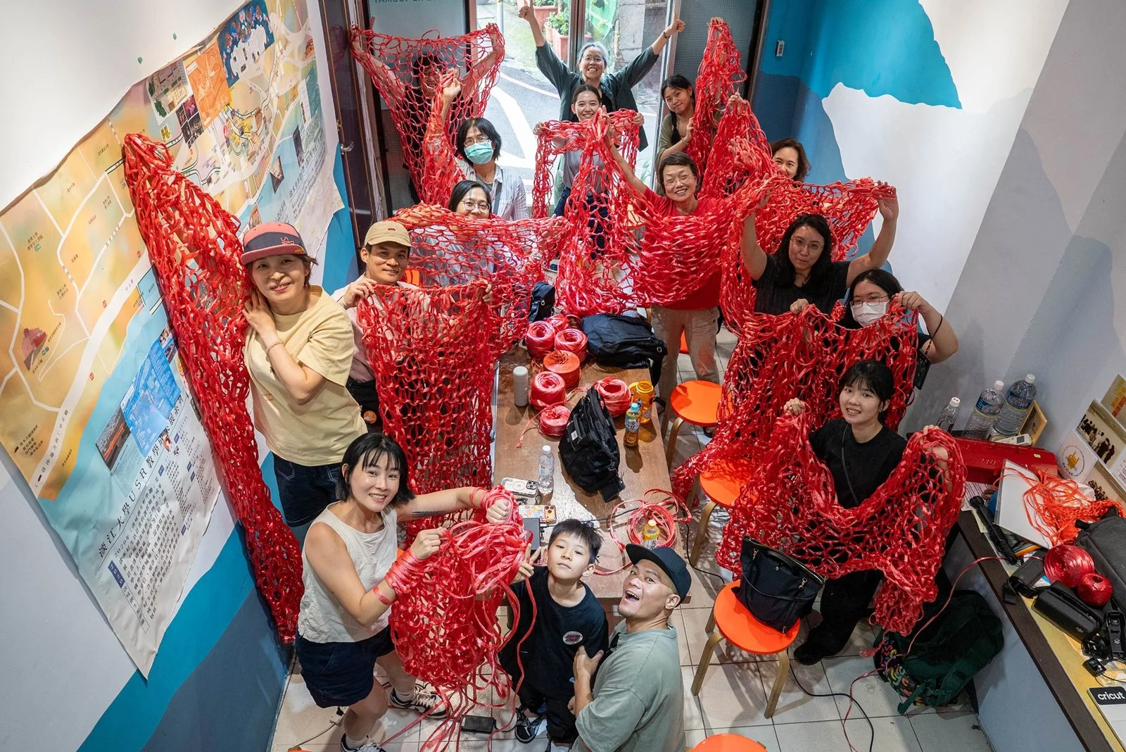 新北藝箱參與者在室內展示共同編織的紅色網狀作品