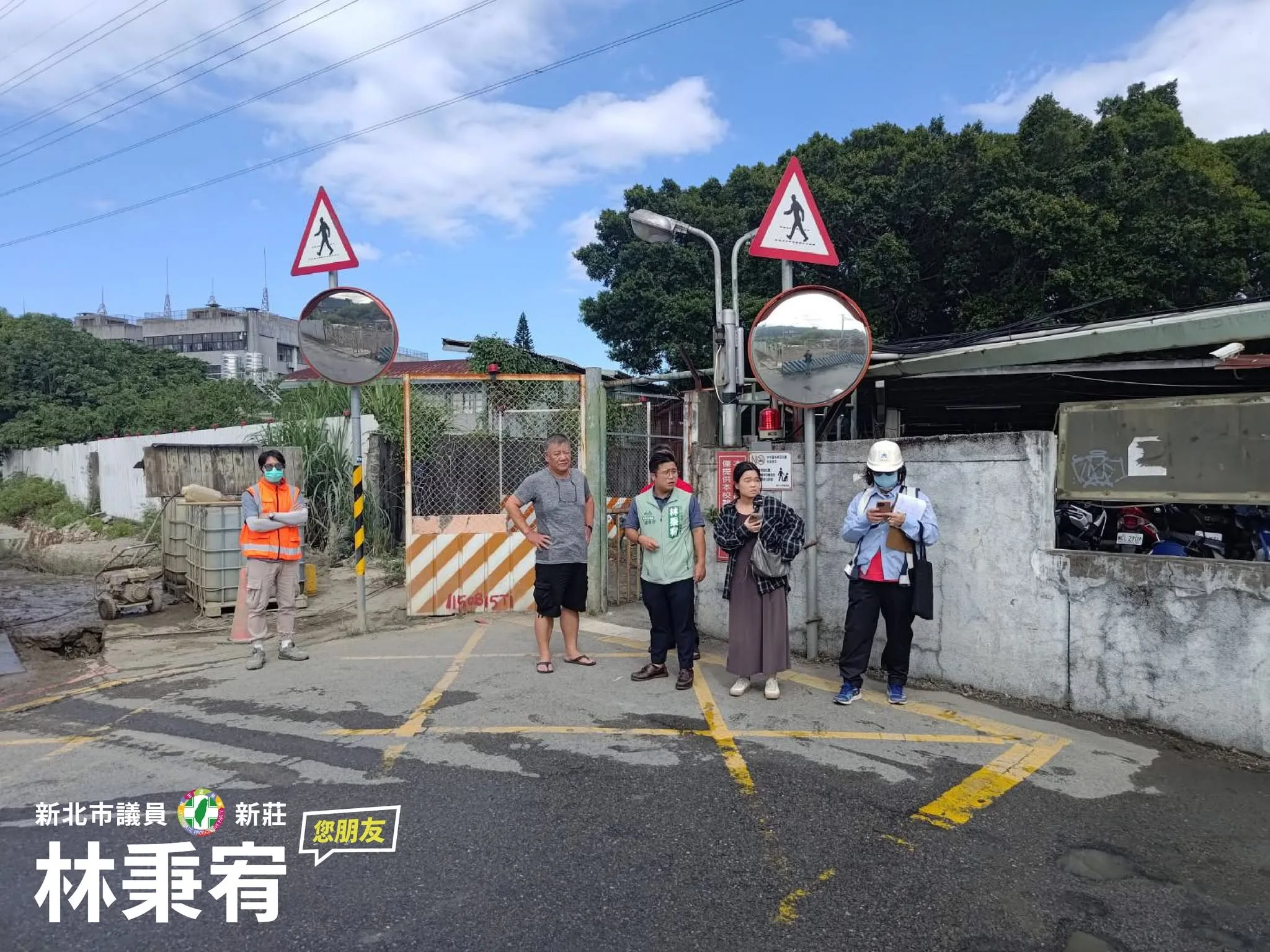 道路會勘參與者站在巷口，周邊設有行人警告標誌及反射鏡